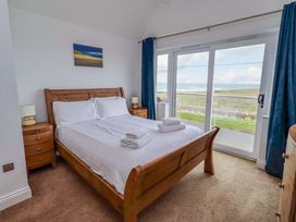 A bedroom with a double bed and a view of the outside at Farne Cottage in Beadnell