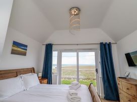 A bedroom with a bed and window at Farne Cottage Beadnell