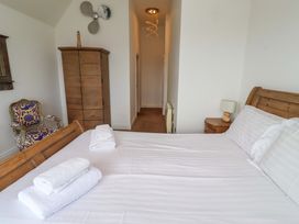 A bedroom with a bed and chair at Farne Cottage in Beadnell