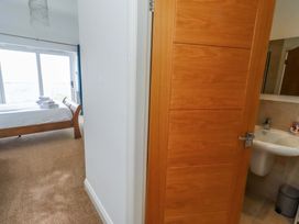 A bedroom with a bed and towels visible at Farne Cottage Beadnell