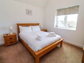 A bedroom with a bed and nightstand at Farne Cottage in Beadnell
