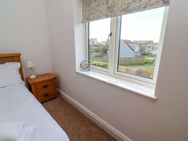 A bedroom with a bed and a window at Farne Cottage Beadnell