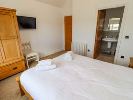 A bedroom with a bed and wardrobe at Farne Cottage in Beadnell