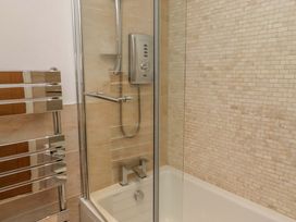 A bathroom with a shower and bathtub at Farne Cottage Beadnell