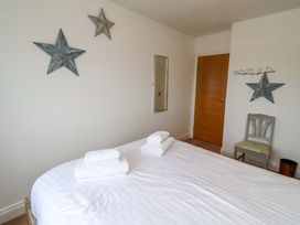 A bedroom with a bed and towels at Farne Cottage in Beadnell