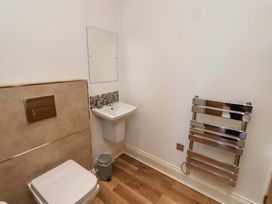 A bathroom with a toilet, sink, and towel rail at Farne Cottage in Beadnell