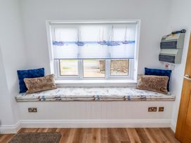 A seating area with a bench and cushions at Farne Cottage in Beadnell