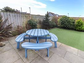 A garden with a blue table and benches at Farne Cottage Beadnell