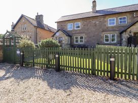 An outdoor view of a house with a fence and grass at Russet in Lucker