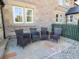 A patio area with four chairs and a green fence at Russet in Lucker