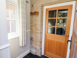 A hallway with a window and wooden door at Russet in Lucker