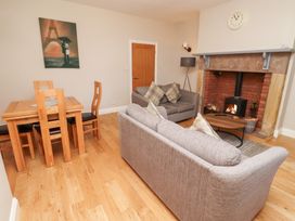 A living room with a dining area and fireplace at Russet in Lucker