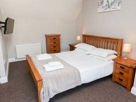 A bedroom with a bed, bedside tables, and a television at Russet in Lucker