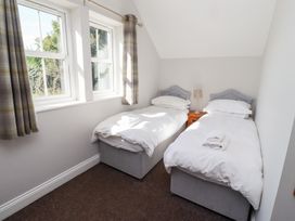A bedroom with two single beds and a bedside table at Russet in Lucker