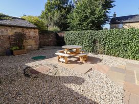 A garden with a gravel area and a wooden table with benches at Russet, Lucker