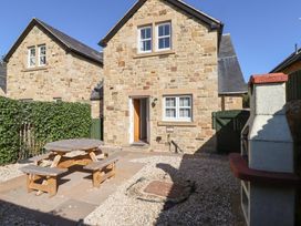 An outdoor area with a stone house and seating at Russet in Lucker