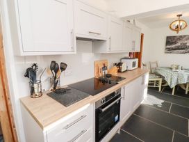 A kitchen with white cabinets stove oven microwave dining table with polka dot tablecloth at Hares Form in Seahouses