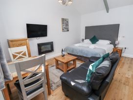 A bedroom with a bed, sofa, and TV at Avocet Cottage - Lucker Steadings Lucker