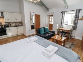 A studio room with a bed and kitchen at Avocet Cottage - Lucker Steadings Lucker