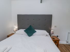 A bedroom with a bed and bedside lamps at Avocet Cottage - Lucker Steadings Lucker