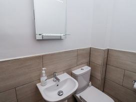 A bathroom with a sink and toilet at Avocet Cottage - Lucker Steadings, Lucker