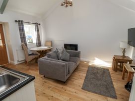 A living room with a table and chairs at Dunlin Cottage - Lucker Steadings in Lucker