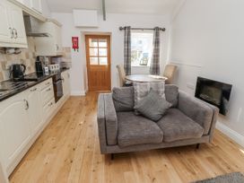 A living room with kitchen and dining area at Dunlin Cottage - Lucker Steadings, Lucker