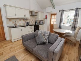 A kitchen with a sofa and dining table at Dunlin Cottage - Lucker Steadings Lucker