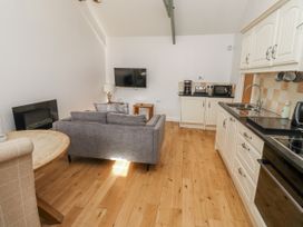 A living room with a sofa and television at Dunlin Cottage - Lucker Steadings in Lucker