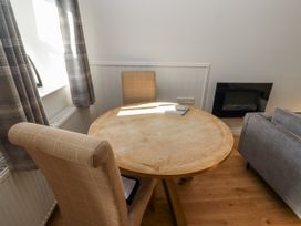 A dining room with a circular table and two chairs at Dunlin Cottage - Lucker Steadings in Lucker