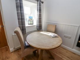 A dining room with a round table and two chairs at Dunlin Cottage - Lucker Steadings in Lucker