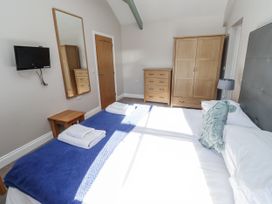 A bedroom with a bed and television at Dunlin Cottage - Lucker Steadings Lucker