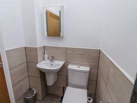 A bathroom with a toilet and wash basin at Dunlin Cottage - Lucker Steadings Lucker