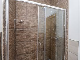 A shower with glass doors and a towel rack at Dunlin Cottage - Lucker Steadings Lucker