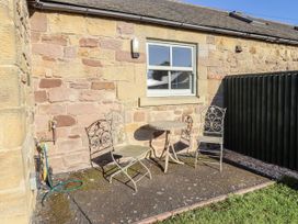 A table with chairs in an outdoor area at Dunlin Cottage - Lucker Steadings Lucker
