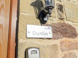A nameplate on a stone wall at Dunlin Cottage - Lucker Steadings in Lucker