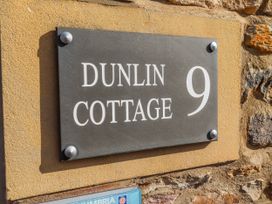 Nameplate displaying Dunlin Cottage 9 on a wall