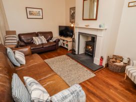 A living room with a sofa, television and fireplace at No9 Budle Sands in Bamburgh