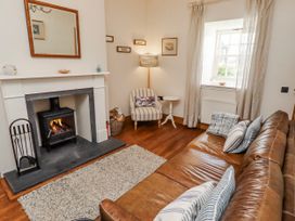 A living room with a fireplace and a sofa at No9 Budle Sands in Bamburgh