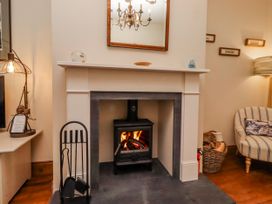 A living room with a fireplace and wooden floor at No9 Budle Sands in Bamburgh