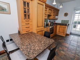 A kitchen with a granite table and wooden cabinets at No9 Budle Sands in Bamburgh
