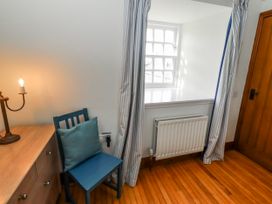 A room with a chair and a desk with a lamp at No9 Budle Sands in Bamburgh