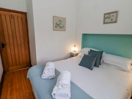 A bedroom with a double bed and artwork on the wall at No9 Budle Sands in Bamburgh