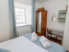 A bedroom with a bed and a desk at No9 Budle Sands in Bamburgh