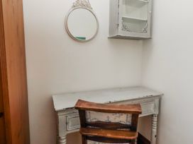 A desk and chair with a mirror and cabinet at No9 Budle Sands in Bamburgh