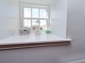 A shelf with a lamp and radio near a window at No9 Budle Sands in Bamburgh