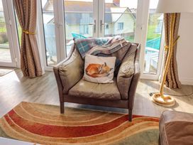 A living room with an armchair and blanket at Spindrifter in Beadnell
