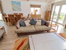 A living room with a sofa and dining area at Spindrifter in Beadnell