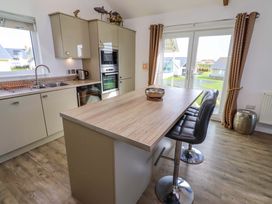 A kitchen with cabinets and a table at Spindrifter Beadnell