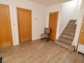 A hallway with doors and a staircase at Spindrifter in Beadnell